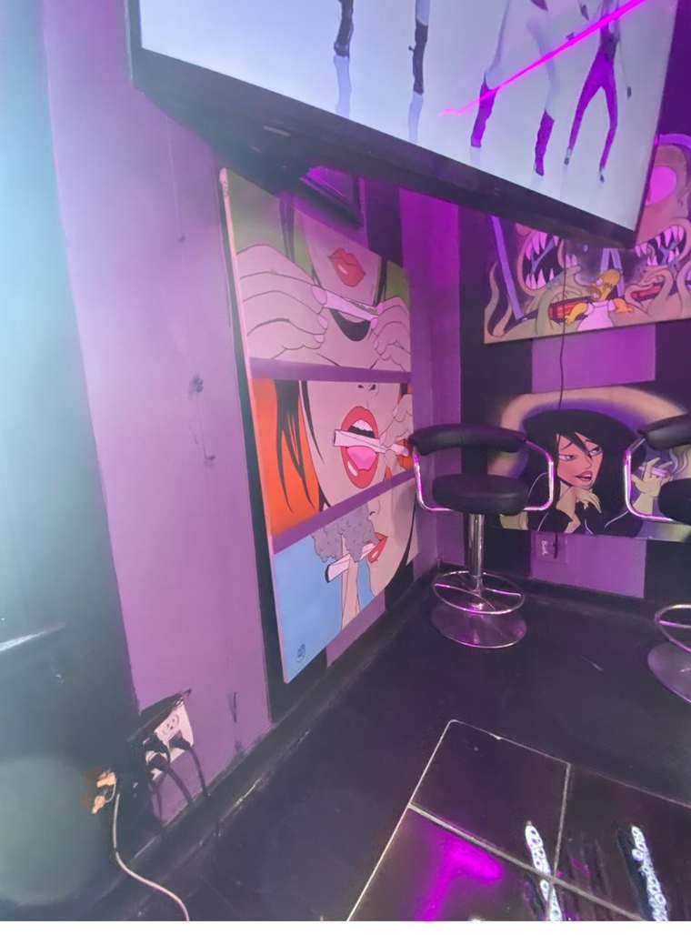 Bar stools beside pop-art canvases